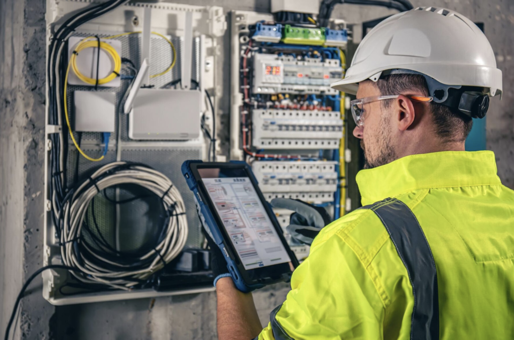 Electrical contractor technician performing safety and compliance inspections on a switchboard.