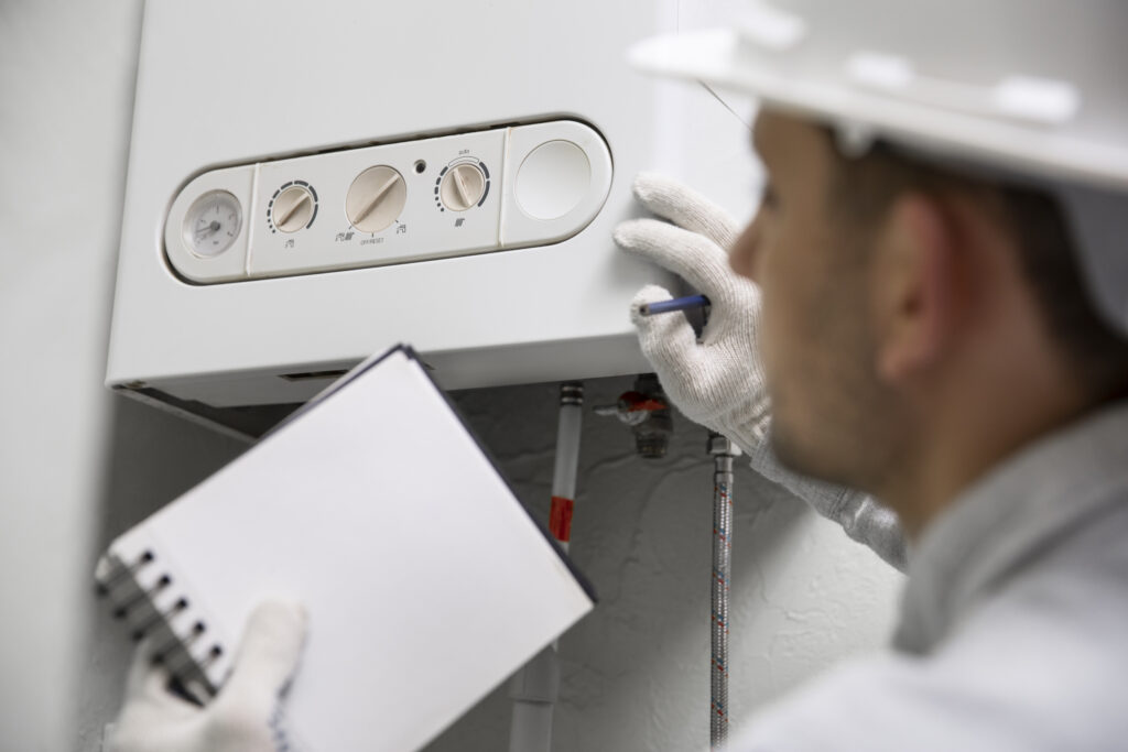 Technician repairing a electrical hot water heater in a residential home, part of electrical maintenance services in Adelaide